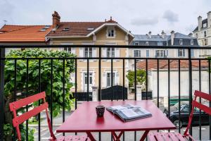 a red table with a book on a balcony at Urban Style Biarritz Le Relais in Biarritz