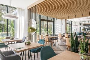 a restaurant with tables and chairs and windows at SZUMY PARK Hotel & Restaurant in Susiec