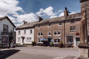 a row of brick buildings on a street at Coffee & Stays at Cartmel Square in Cartmel