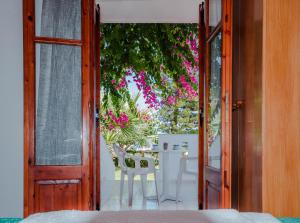 an open door to a patio with a table and flowers at Antigoni Apartments 'Lavender Room' in Milatos