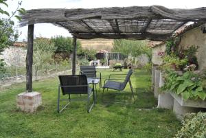 Carbonero de Ahusín的住宿－Casa Rural Los Secretos，凉棚下一组椅子和一张桌子