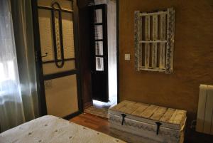 Habitación con puerta, cama y ventana en Casa Rural Los Secretos, en Carbonero de Ahusín