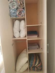 um armário com prateleiras brancas e toalhas dobráveis em Аренда 2-ух комнатная посуточно em Balkhash