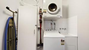 a bathroom with a sink and a washing machine at Altitude in Dinner Plain +11 photos