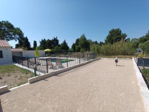 un niño pequeño caminando por una acera junto a un parque infantil en Maison indépendante avec piscine, 10min Avignon, en Pujaut
