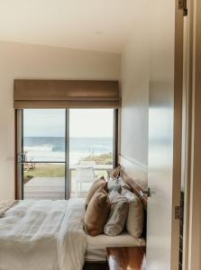 a bedroom with a bed with a view of the ocean at Hearns Beachside Villa 9 in Port Fairy