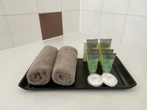 a black tray with three towels and two cups at Central Highlands Motor Inn in Kyneton