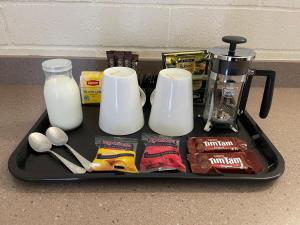 una bandeja con leche y otros ingredientes en un mostrador en Central Highlands Motor Inn, en Kyneton