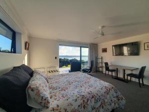 a bedroom with a bed and a table and a window at Makuri Bay Hideaway in Purerua