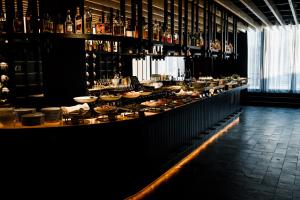 a bar with a long counter with plates of food at Roomers Munich, Autograph Collection in Munich