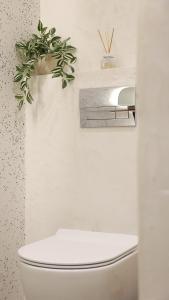 een badkamer met een toilet en een plant erboven bij Thermes private suites in Loutraki