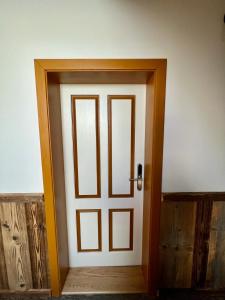 uma porta branca com uma moldura de madeira num quarto em Vila Liberta em Poprad