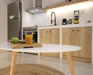 a white table in a kitchen with a glass of juice at Thermes private suites in Loutraki