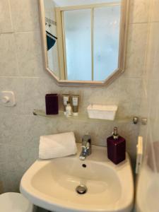 bagno con lavandino, specchio e servizi igienici di Casa Giulia a Santo Stefano al Mare