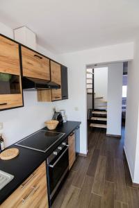 een keuken met een zwart aanrecht en houten kasten bij Passatempo Apartment Ireon in Samos