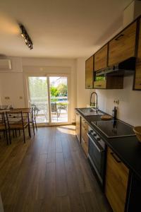 a kitchen with wooden floors and a table with chairs at Passatempo Apartment Ireon in Samos