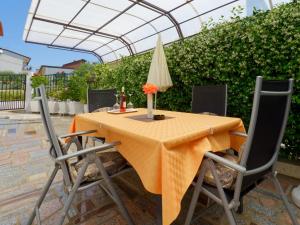 een tafel met twee stoelen en een parasol bij Holiday Home Nevena in Buje