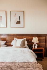 a bedroom with a bed with a wooden headboard at Hearns Beachside Villa 9 in Port Fairy