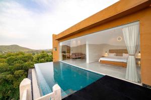 a villa with a swimming pool and a bedroom at YAAN Udaipur in Udaipur