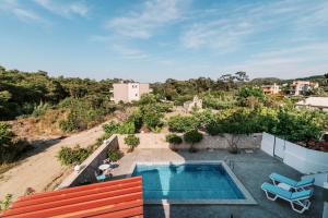 a house with a swimming pool on top of a hill at Greek Style Apartment with Jaquzzi & Barbeque in Triánta