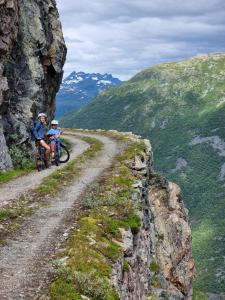 two people riding bikes on a mountain road at New, Mountain paradise, fishing, biking, mountaineering in Tyinkrysset
