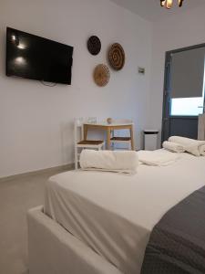 a bedroom with two beds and a flat screen tv at Traditional house under the castle in Astypalaia