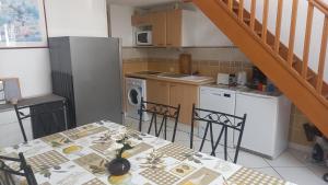 una cucina con tavolo, sedie e scala di St Pierre la Mer maison 3 chambres 6 couchages a Saint Pierre La Mer