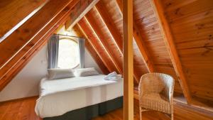 a bedroom in a attic with a bed and a chair at Wrens View in Dinner Plain