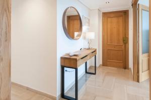 a bathroom with a mirror and a wooden table at Ag Aiguablava in Gandía