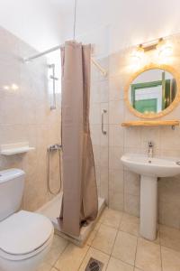 a bathroom with a toilet a sink and a shower at D&G Apartments in Agia Paraskevi