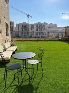 un patio con mesa, sillas y césped en דירת גן מהממת בבית שמש, en Bet Shemesh
