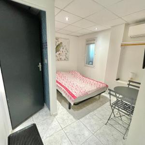 a bedroom with a bed and a table in it at Le Mas Des Oliviers in Agde