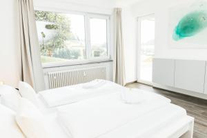 Habitación blanca con sofá blanco y ventana en HEIMATEL - Ferienwohnung Bergblick, en Wangen im Allgäu