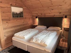 a bedroom with two beds in a wooden cabin at Tradisjonell laftet hytte in Vradal