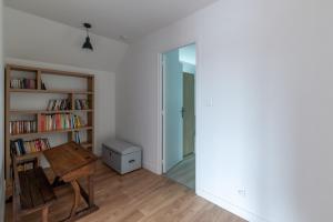 a room with a table and a book shelf at Gîte du Tilleul - Maison climatisée pour 8 voyageurs in Houesville