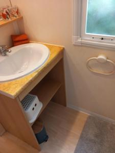 La salle de bains est pourvue d'un lavabo et d'une fenêtre. dans l'établissement Mobile home au camping les Tilleuls du Caminel, à Sarlat-la-Canéda