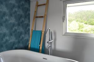 a bathroom with a sink and a window at O Cabanel de Ali in Muxia