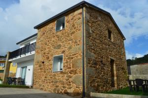 a brick building with windows on the side of it at O Cabanel de Ali in Muxia