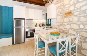 a kitchen with a table and chairs and a stone wall at Villa Fegari in Mochlos
