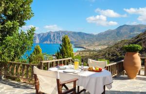 a table with food and a view of the ocean at Villa Fegari in Mochlos