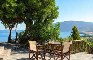 a table and chairs on a patio with a view of the ocean at Villa Fegari in Mochlos