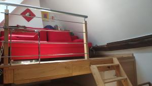 een rode bank bovenop een hoogslaper bij Location maison de vacances Sancerre in Sancerre