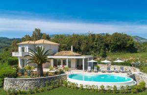 een villa met een zwembad en een huis bij Villa Eva in Ágios Stéfanos