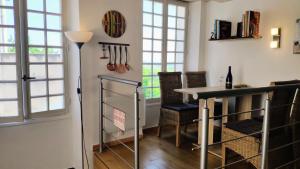 een eetkamer met een tafel en een aantal ramen bij Location maison de vacances Sancerre in Sancerre +27 foto's