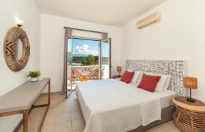 een slaapkamer met een bed en een balkon bij Villa Eva in Ágios Stéfanos