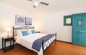 een slaapkamer met een bed en een blauwe deur bij Villa Ilios in Mochlos