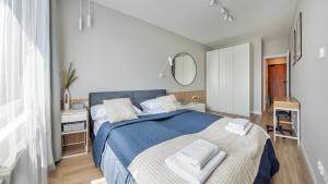a bedroom with a blue bed with towels on it at Apartamenty Sun & Snow Baltea in Gdańsk