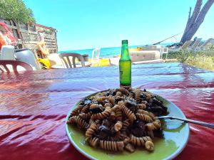 a plate of food on a table with a bottle at Caravane on the beach in Lucciana