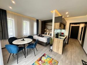Habitación de hotel con cama, mesa y sillas en Luxury Apartments Keszthely en Keszthely