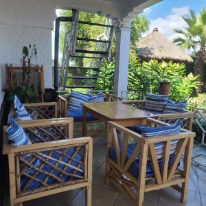 a patio with tables and chairs and a thatched roof at Volcano View in Ruhengeri